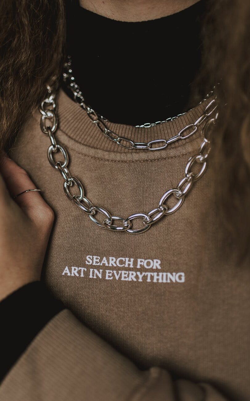 faceless stylish woman in chain necklace and sweatshirt